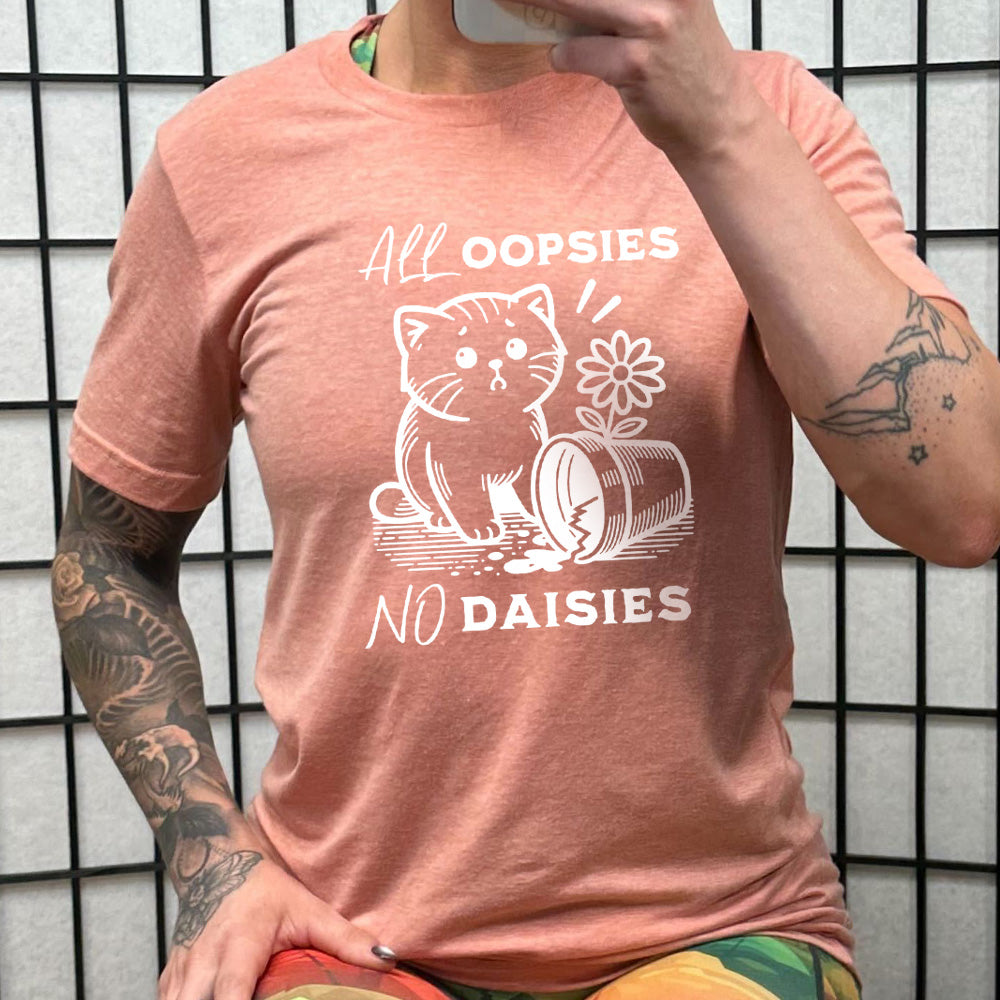 peach shirt with the text "All Oopsies, No Daisies" on it