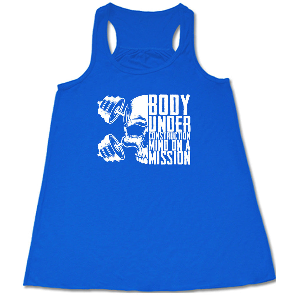 blue shirt with the text "Body Under Construction, Mind on a Mission" on it