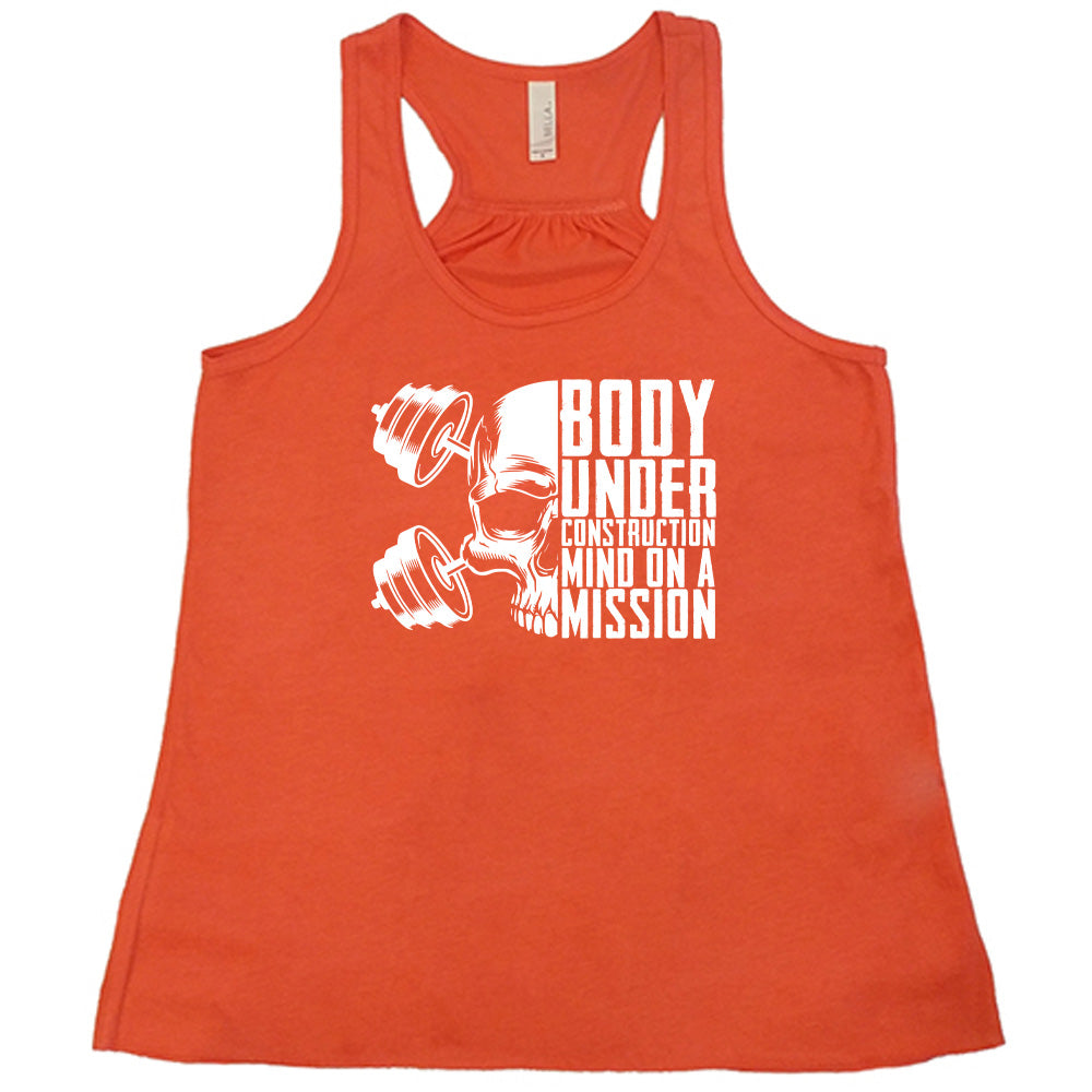 coral shirt with the text "Body Under Construction, Mind on a Mission" on it