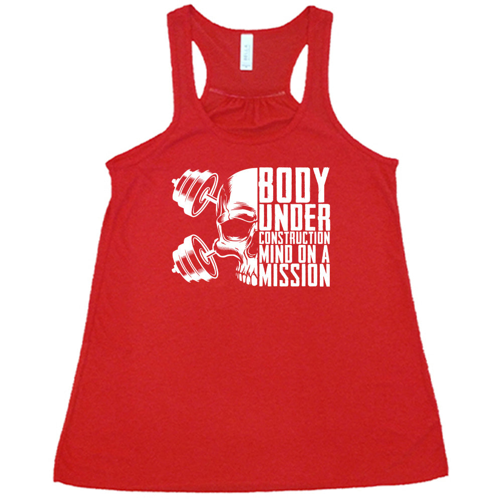 red shirt with the text "Body Under Construction, Mind on a Mission" on it