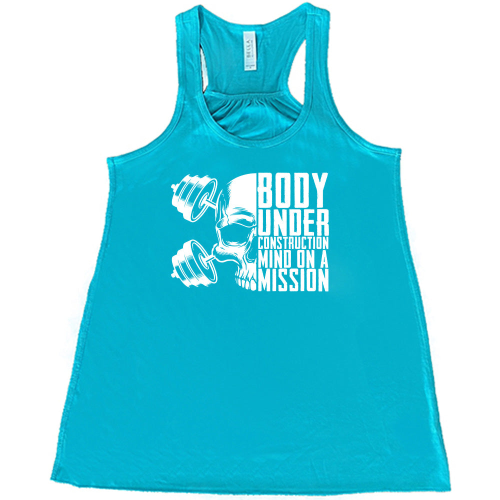 teal shirt with the text "Body Under Construction, Mind on a Mission" on it