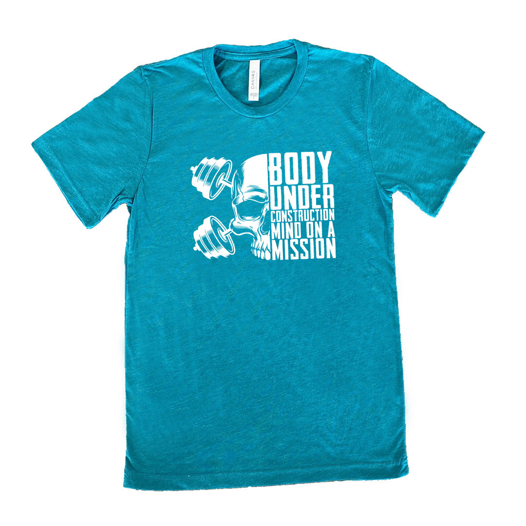 teal shirt with the text "Body Under Construction, Mind on a Mission" on it