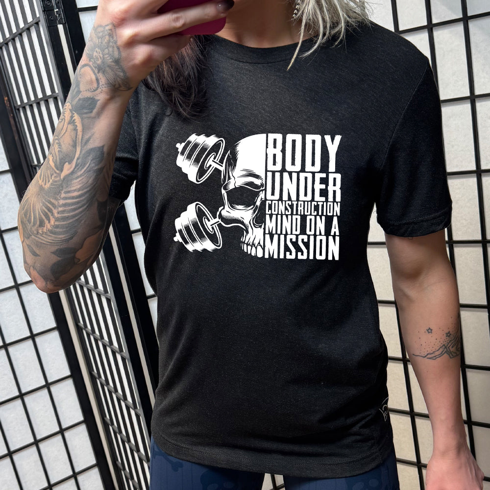 black shirt with the text "Body Under Construction, Mind on a Mission" on it