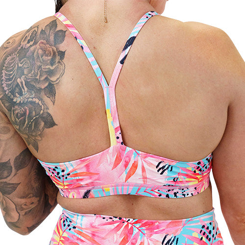 back of the bright colored palm tree leaf patterned sports bra