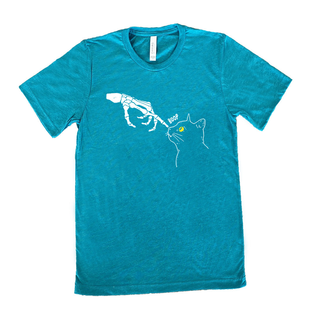 teal shirt with a skeleton hand tapping a cats nose graphic