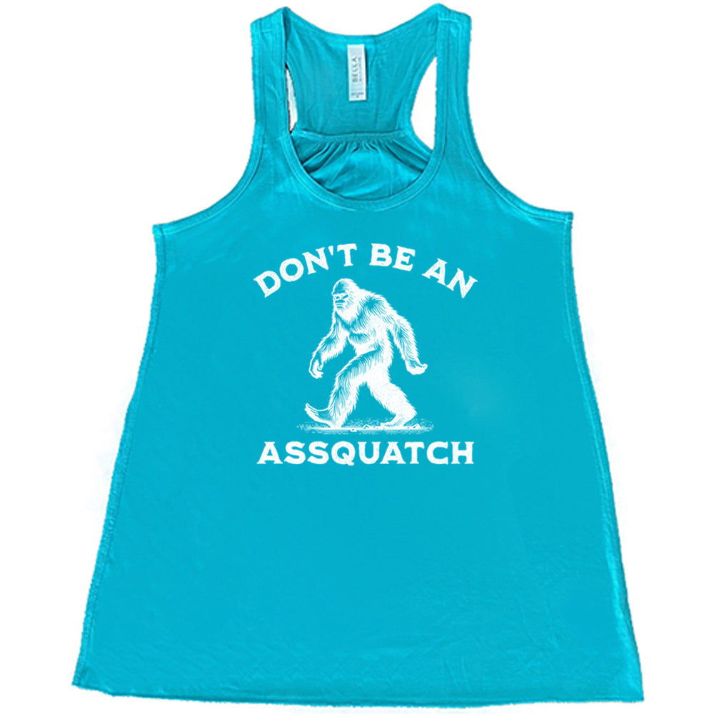 teal shirt with the text "Don't Be An Assquatch" on it