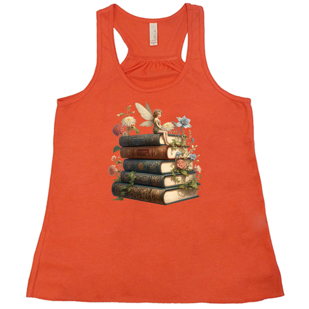 coral shirt with a fairy sitting on books graphic in the center