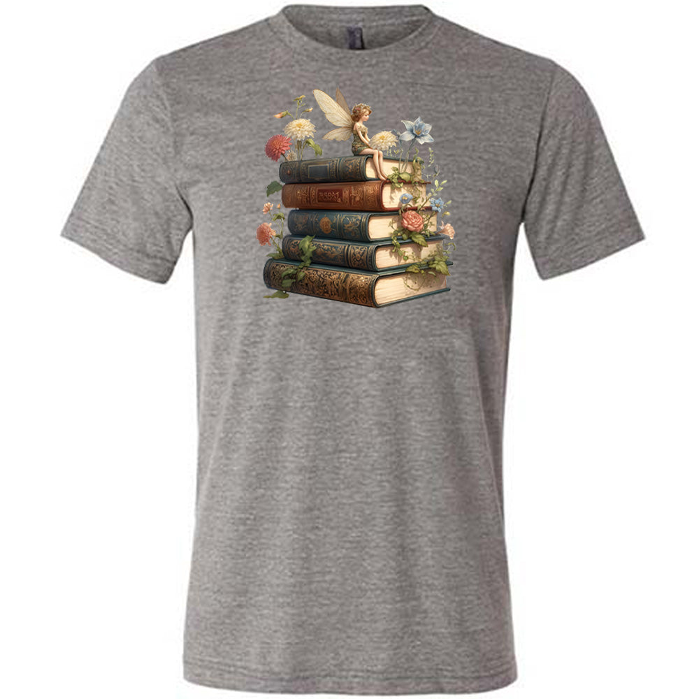 grey shirt with a fairy sitting on books graphic in the center