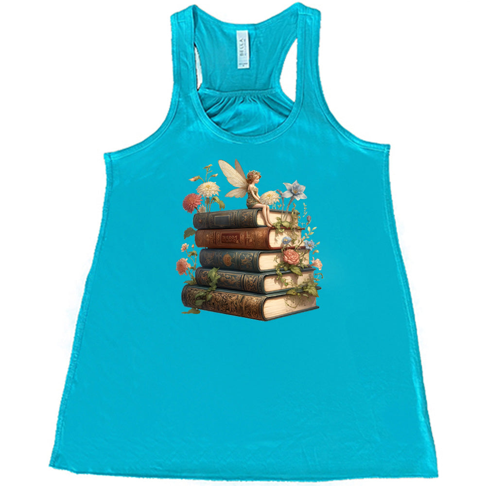 teal shirt with a fairy sitting on books graphic in the center