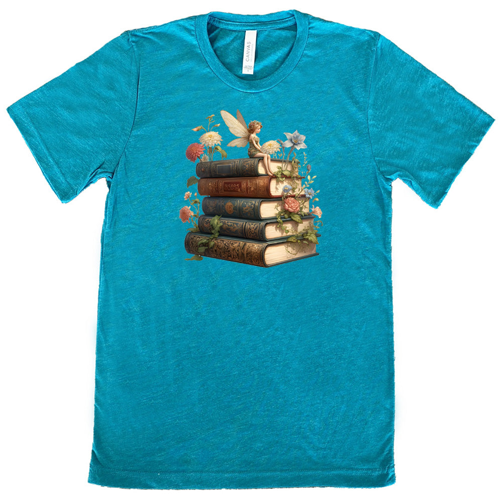 teal shirt with a fairy sitting on books graphic in the center