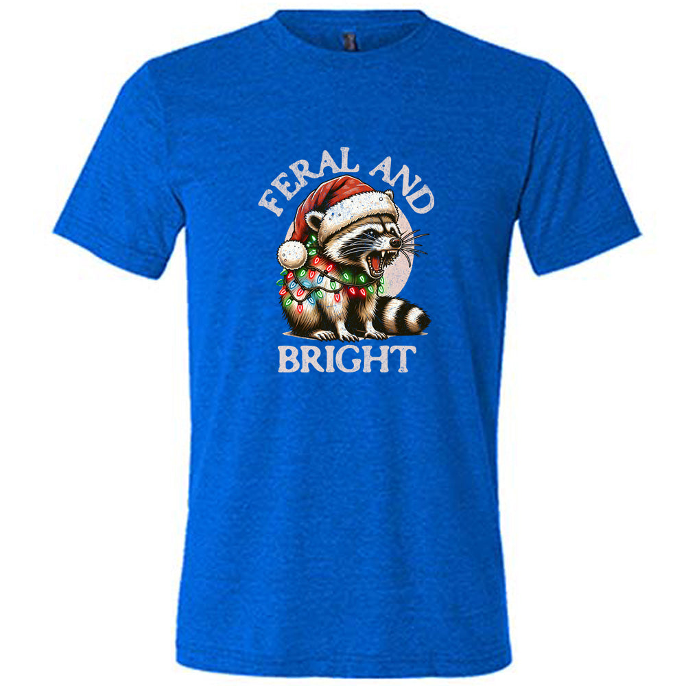 blue shirt with the text "Feral And Bright" with a raccoon graphic on it