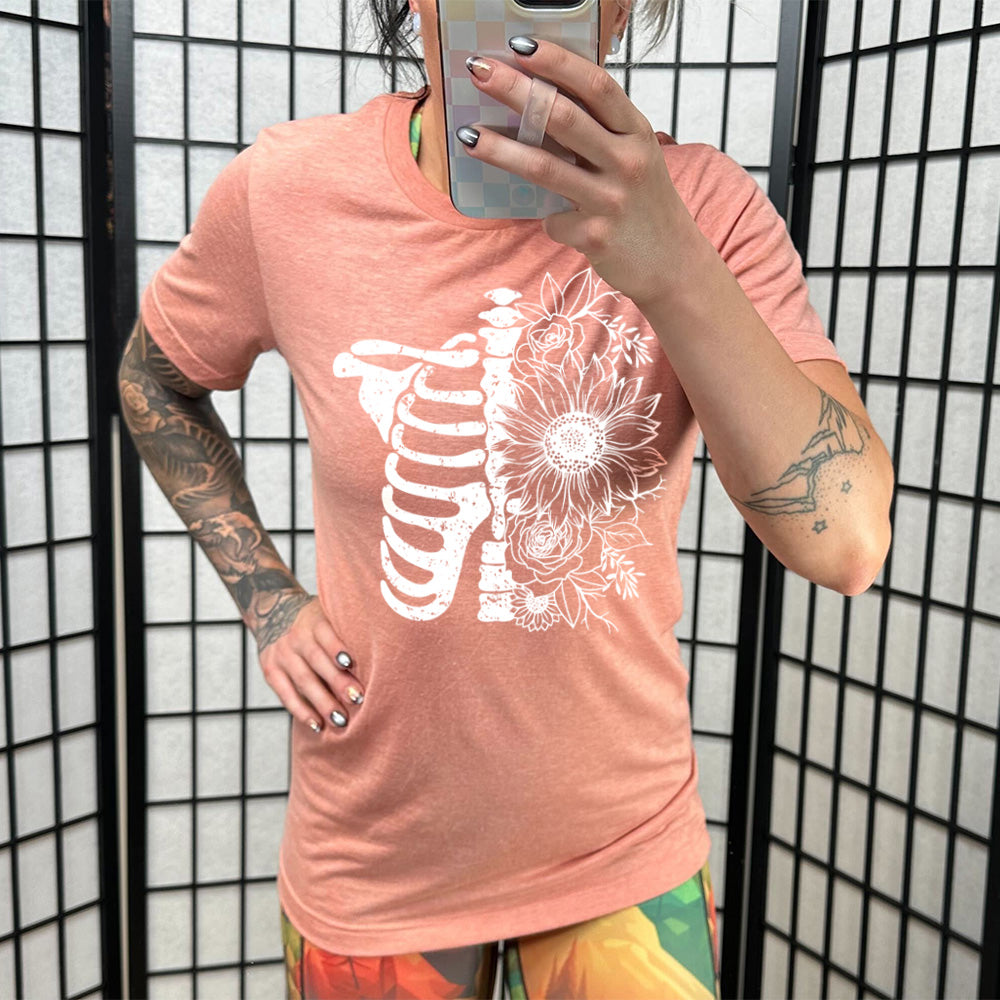 coral shirt with a white Floral Ribcage graphic on it