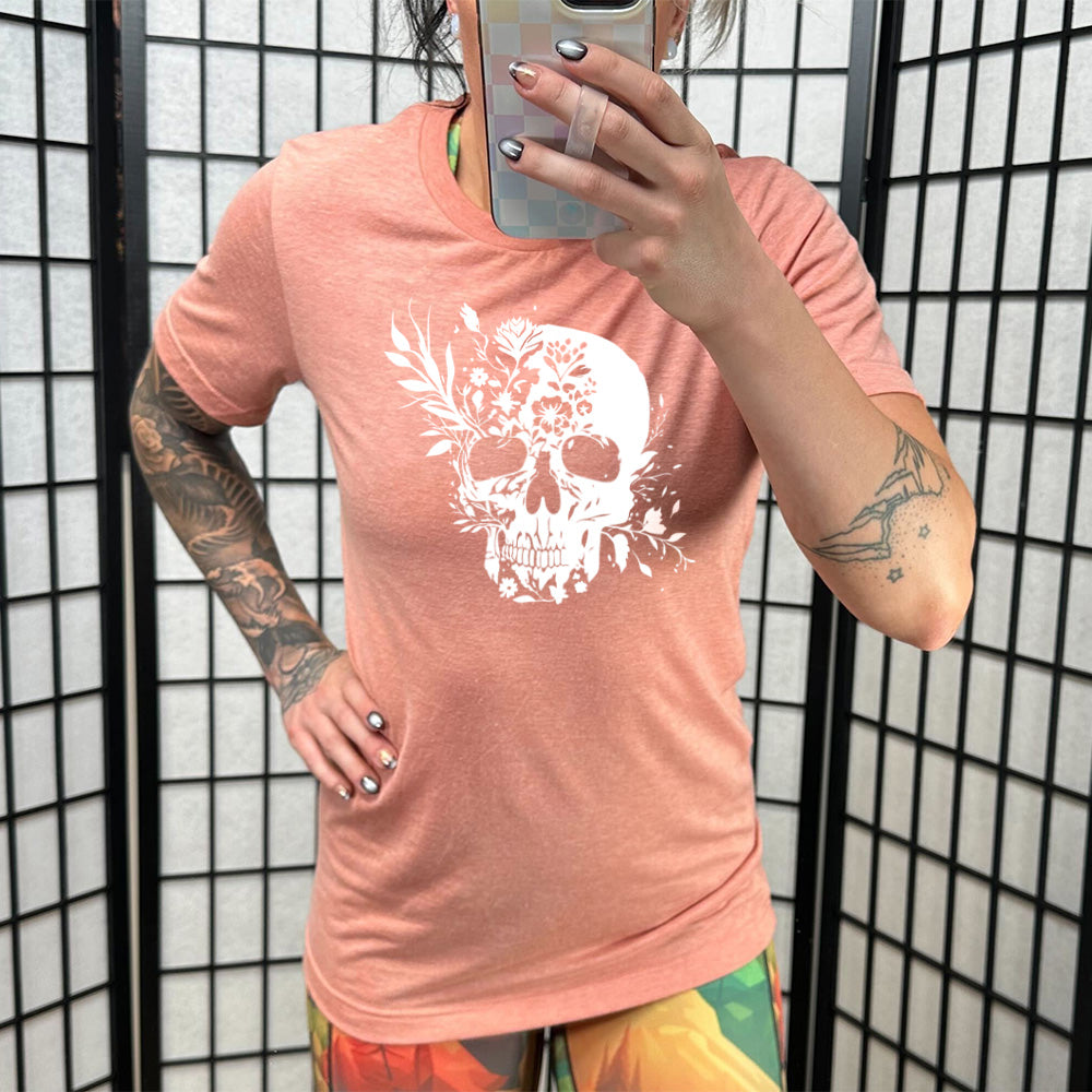 coral shirt with a white floral skull graphic on it