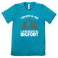 teal shirt with the text "I Believe In You I Also Believe In Bigfoot" on it