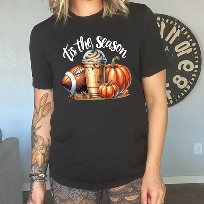 black shirt with a football, coffee and pumpkin graphic on it with the quote "tis the season" on it