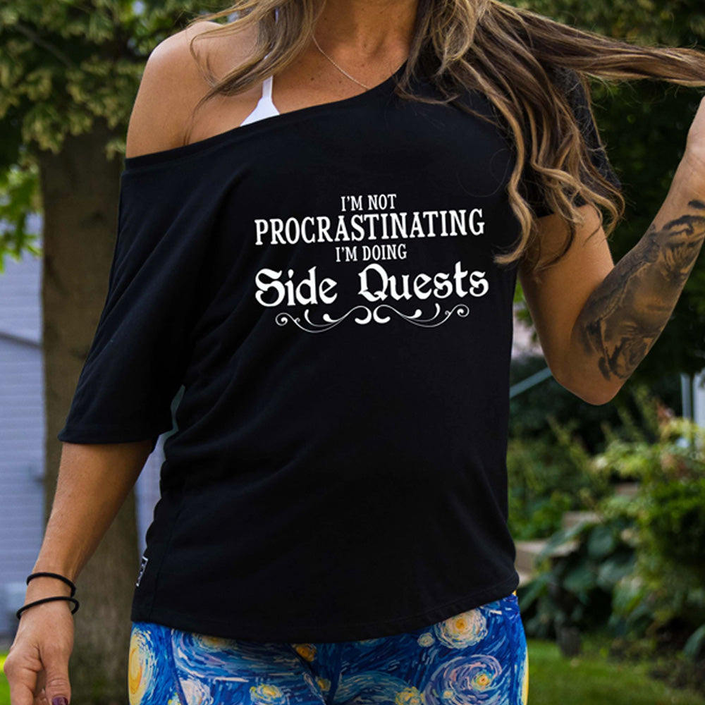 slouchy shirt with the text "I'm Not Procrastinating I'm Doing Side Quests" on it