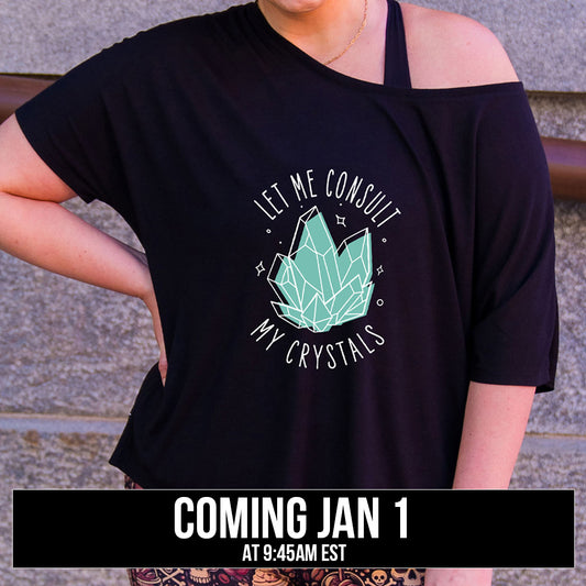 black slouchy shirt with the text "Let Me Consult My Crystals" on it coming soon