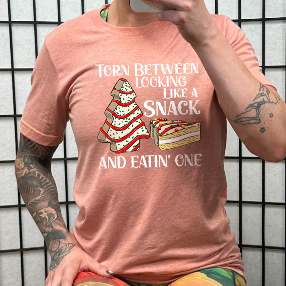 peach shirt with the text "Torn Between Looking Like A Snack And Eating One" on it