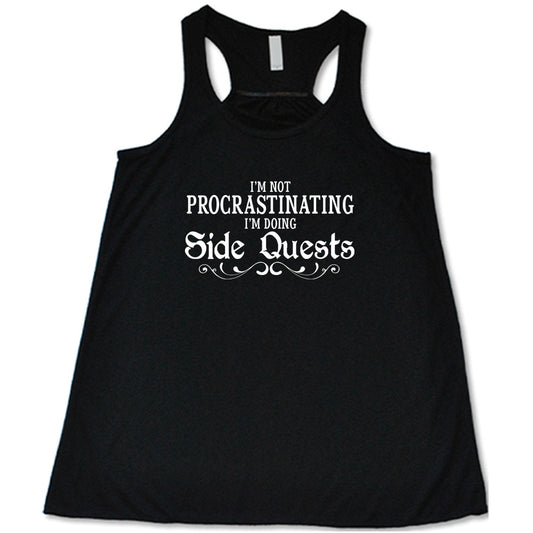 black shirt with the text "I'm Not Procrastinating I'm Doing Side Quests" on it