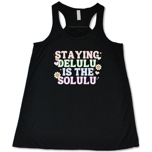 black shirt with the text "Staying Delulu Is The Solulu" on it