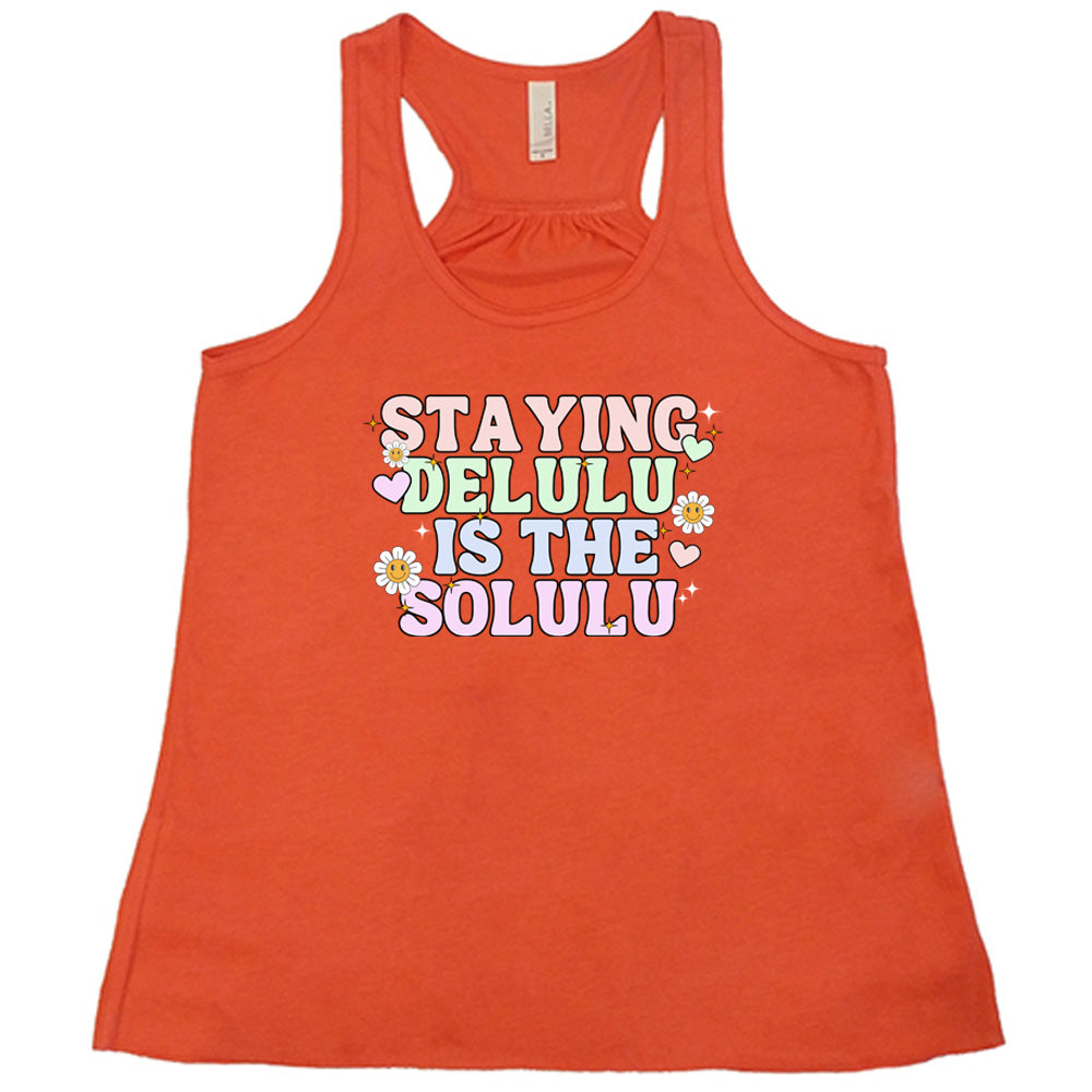 coral shirt with the text "Staying Delulu Is The Solulu" on it