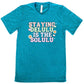 teal shirt with the text "Staying Delulu Is The Solulu" on it