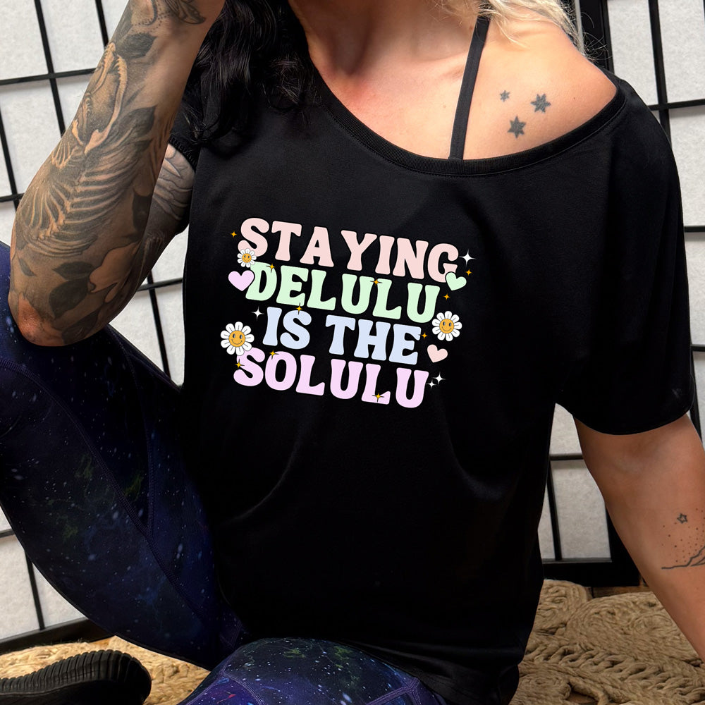 black slouchy shirt with the text "Staying Delulu Is The Solulu" on it