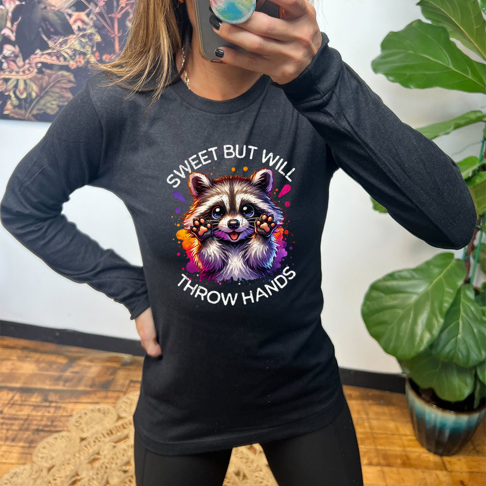 black shirt with the text "Sweet But Will Throw Hands" and a graphic of a raccoon on it