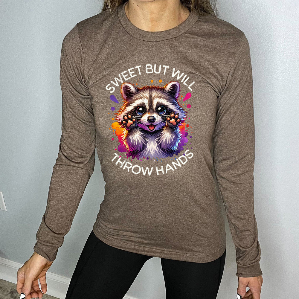 brown shirt with the text "Sweet But Will Throw Hands" and a graphic of a raccoon on it