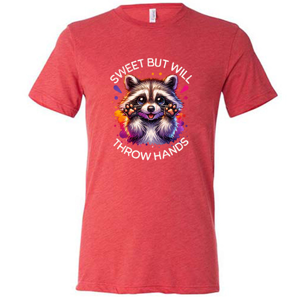 red shirt with the text "Sweet But Will Throw Hands" and a graphic of a raccoon on it