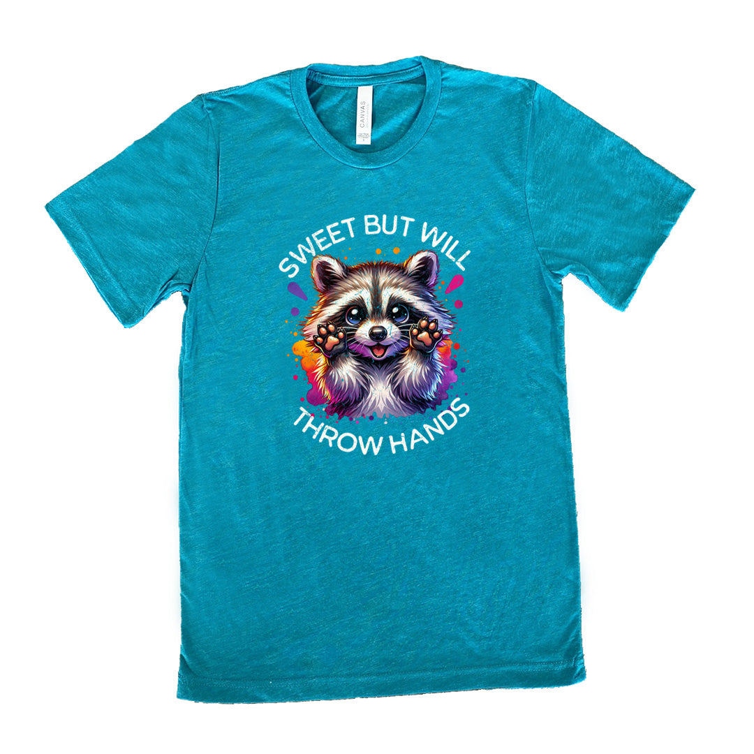 teal shirt with the text "Sweet But Will Throw Hands" and a graphic of a raccoon on it