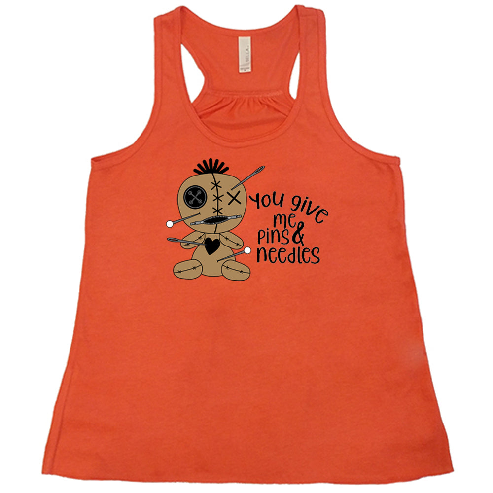 coral shirt with a voodoo doll graphic and the quote "You Give Me Pins And Needles" on it