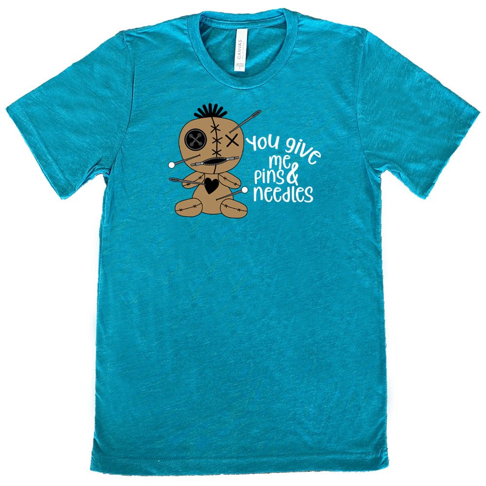 teal shirt with a voodoo doll graphic and the quote "You Give Me Pins And Needles" on it