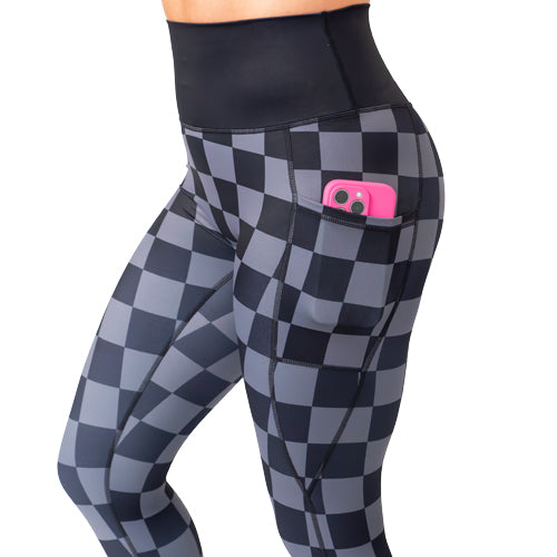 close up of the pocket of the black checkers leggings with a phone in the pocket