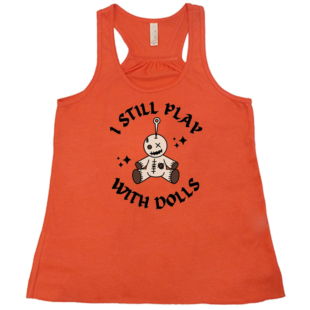 coral shirt that has a voodoo doll graphic and the text "i still play with dolls" on it