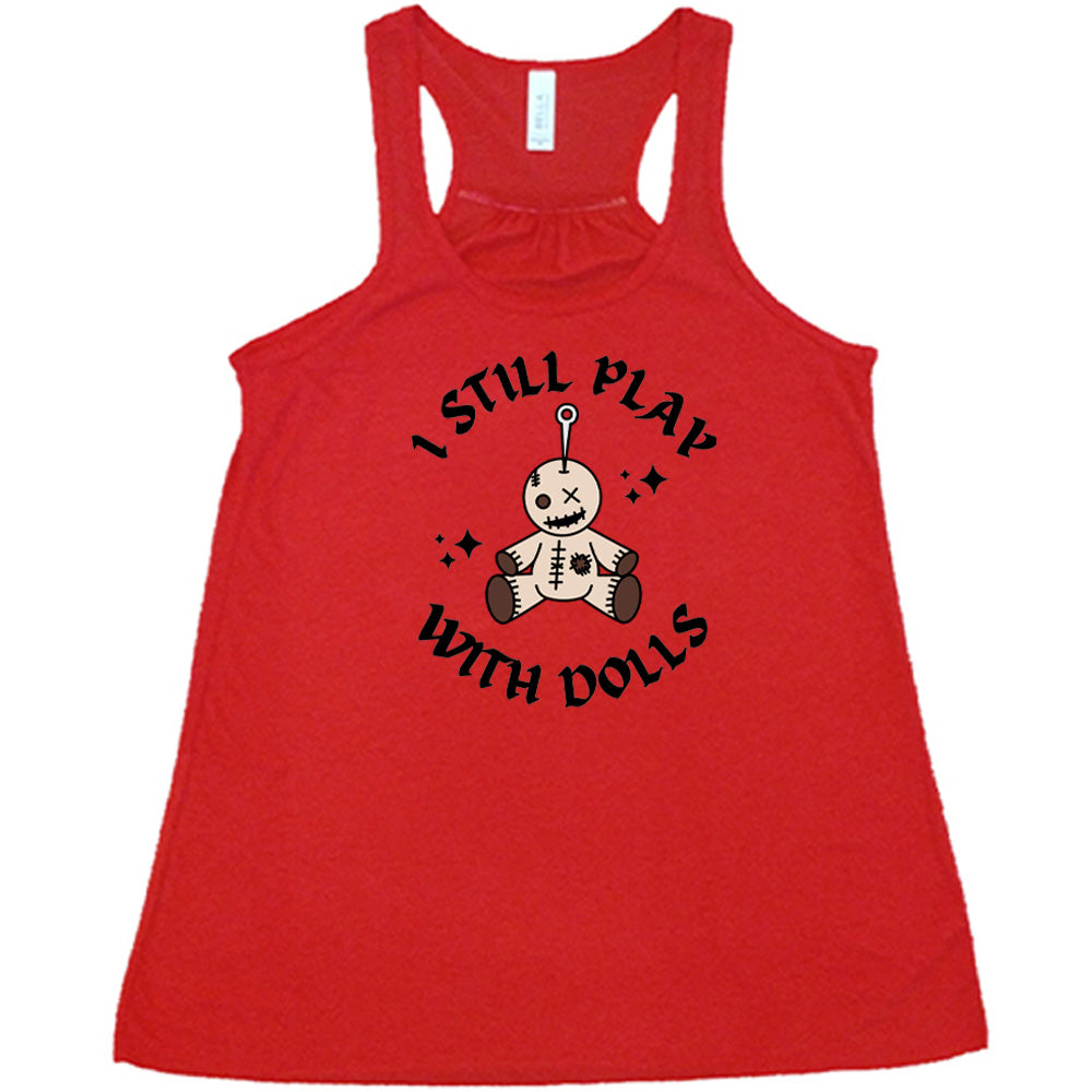 red shirt that has a voodoo doll graphic and the text "i still play with dolls" on it