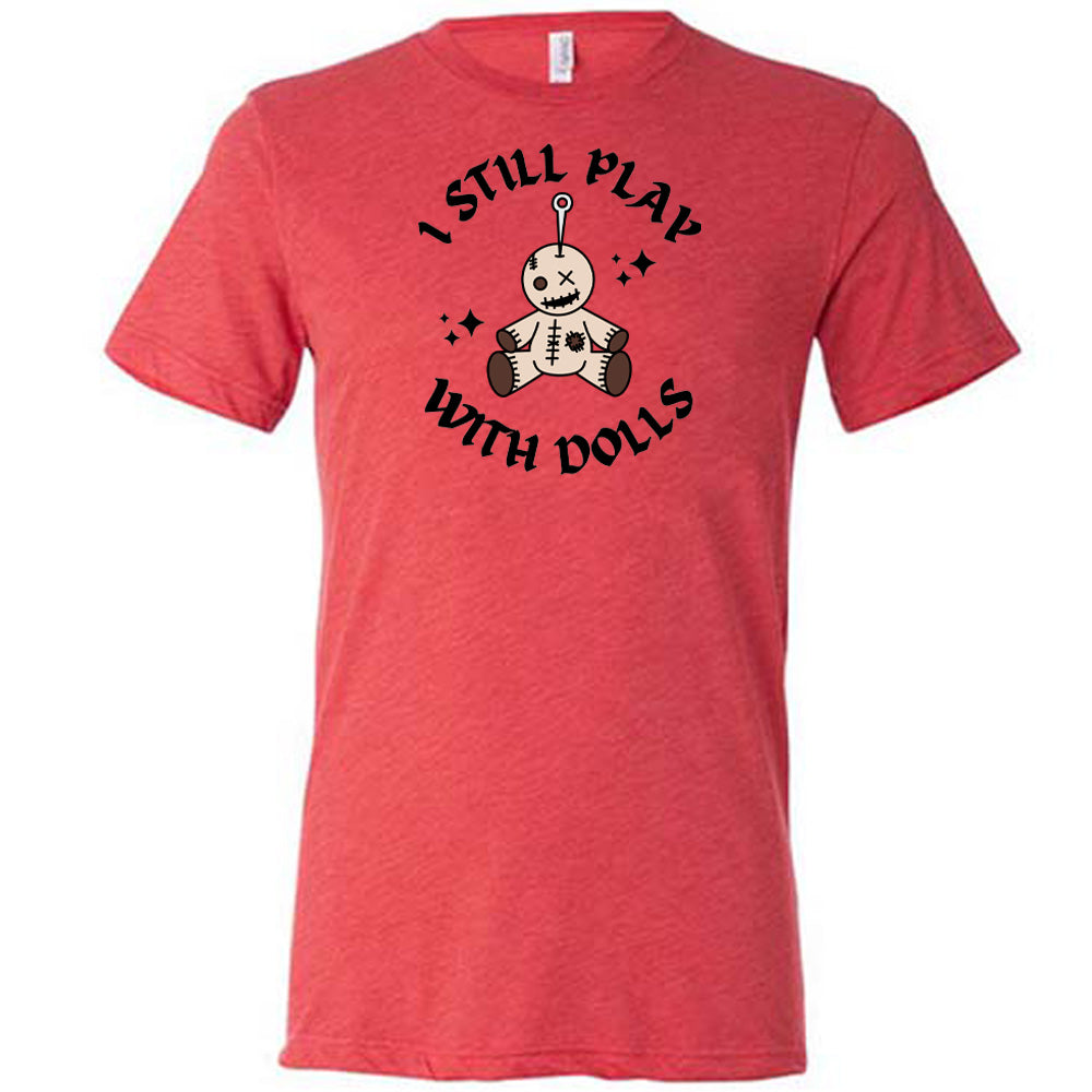 red shirt that has a voodoo doll graphic and the text "i still play with dolls" on it