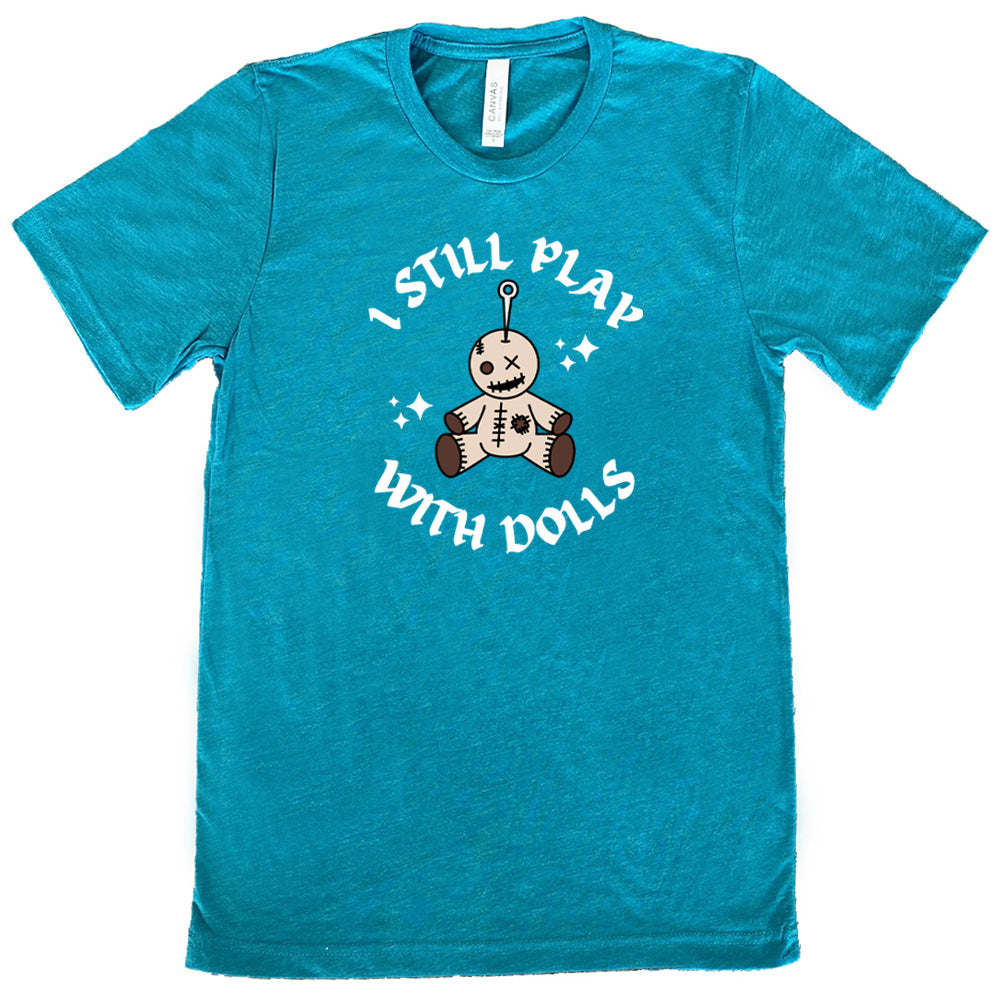 teal shirt that has a voodoo doll graphic and the text "i still play with dolls" on it