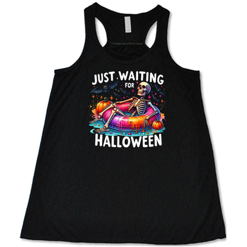 black shirt with a colorful skeleton graphic in the center with the quote "Just Waiting For Halloween" on it