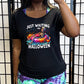 model wearing the black slouchy shirt with a colorful skeleton graphic in the center with the quote "Just Waiting For Halloween" on it