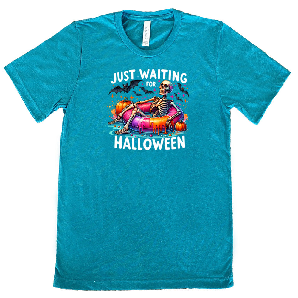 teal shirt with a colorful skeleton graphic in the center with the quote "Just Waiting For Halloween" on it