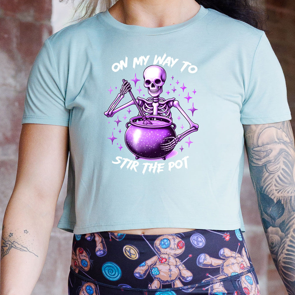 blue cropped tee with a skeleton graphic and the quote "on my way to stir the pot" on it