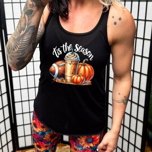 model wearing a black tank top with the saying "tis the season" and has pumpkins, iced coffee, and football